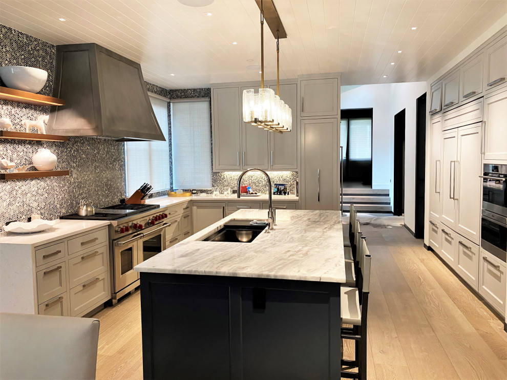 Inspiration for a large contemporary u-shaped open plan kitchen in Other with an undermount sink, recessed-panel cabinets, white cabinets, grey splashback, panelled appliances, light hardwood floors, with island, brown floor, white benchtop and timber.