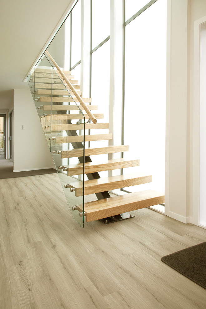 Photo of a large scandinavian wood floating staircase in Wellington with open risers.