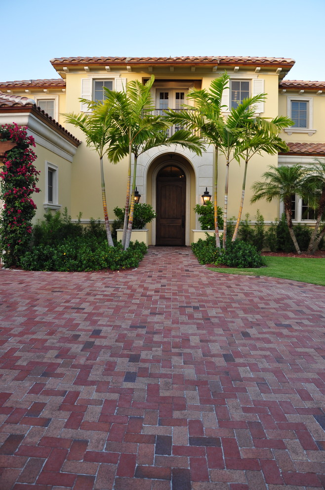 Inspiration for a large mediterranean two-storey stucco yellow exterior in Miami.