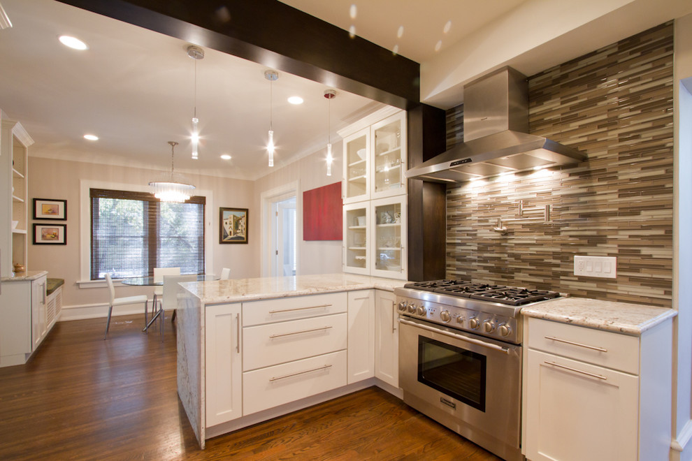 Mid-sized contemporary u-shaped separate kitchen in Denver with a farmhouse sink, shaker cabinets, white cabinets, granite benchtops, metallic splashback, glass tile splashback, stainless steel appliances, medium hardwood floors, a peninsula and brown floor.