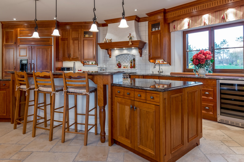 Design ideas for a large traditional l-shaped open plan kitchen in Ottawa with a farmhouse sink, recessed-panel cabinets, medium wood cabinets, granite benchtops, white splashback, ceramic splashback, stainless steel appliances, limestone floors and with island.
