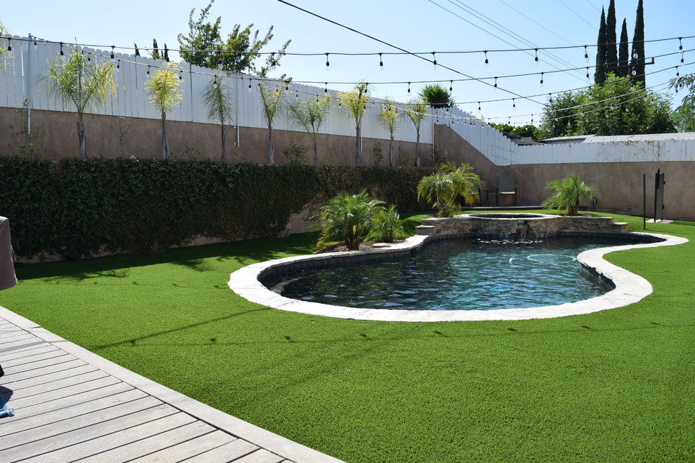 Design ideas for a large transitional backyard custom-shaped pool in Los Angeles with a hot tub.