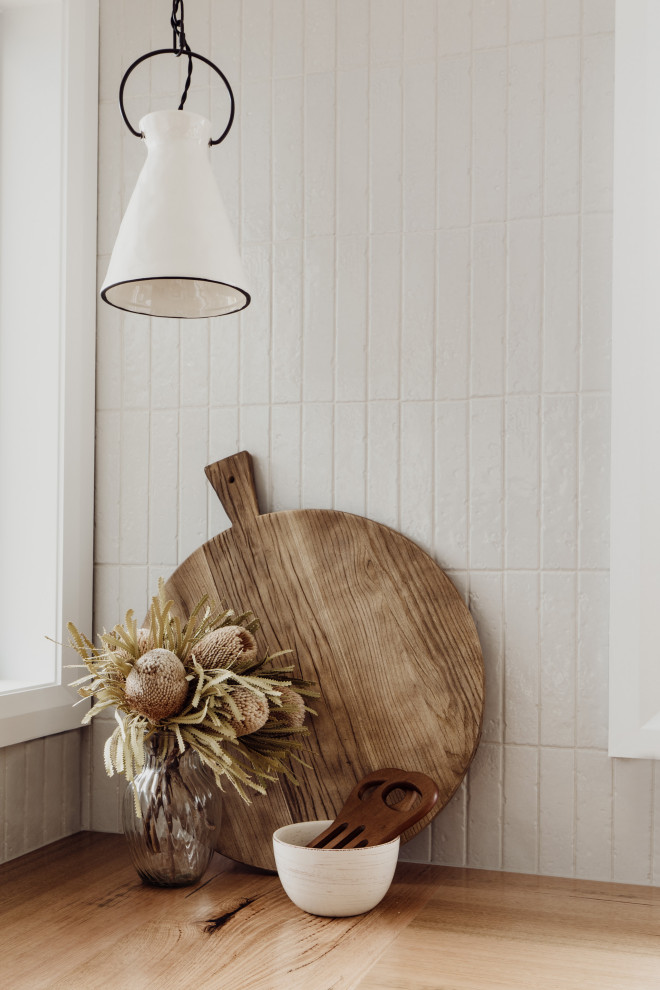 Transitional kitchen in Hobart with a farmhouse sink, shaker cabinets, green cabinets, wood benchtops, white splashback, cement tile splashback and stainless steel appliances.