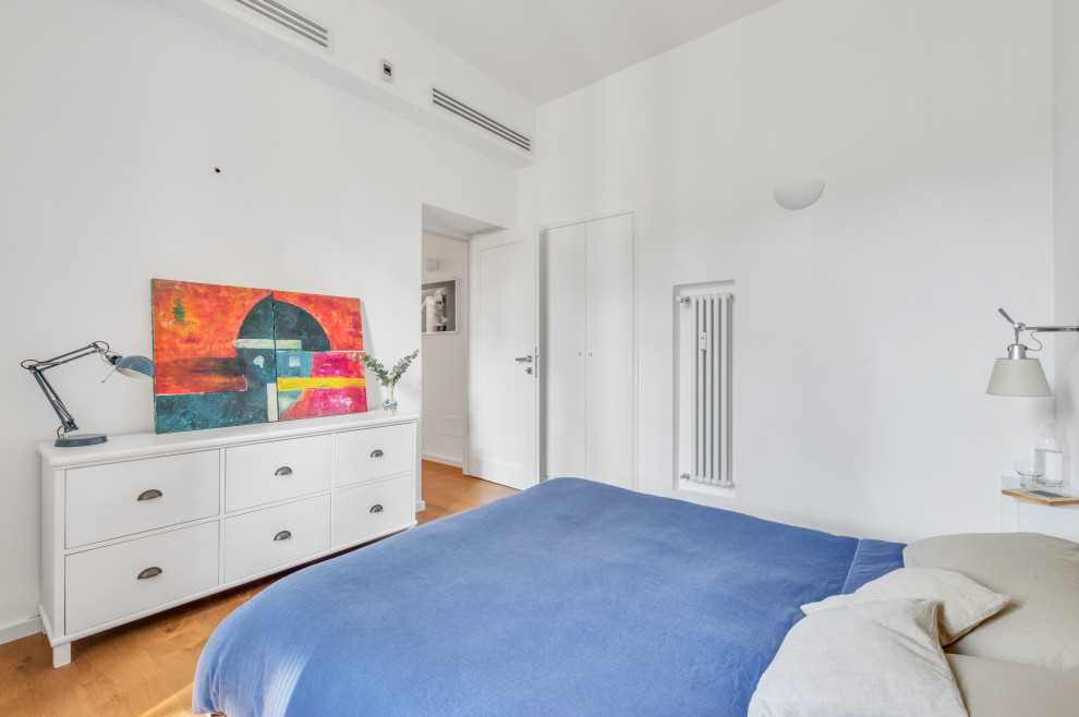 Foto di una camera matrimoniale minimalista di medie dimensioni con pareti bianche, parquet scuro e pavimento marrone