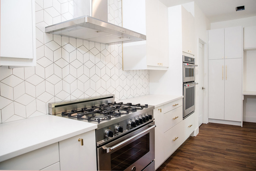 Eat-in kitchen - large transitional u-shaped vinyl floor and brown floor eat-in kitchen idea in Austin with an undermount sink, flat-panel cabinets, white cabinets, quartz countertops, white backsplash, stainless steel appliances, an island and white countertops