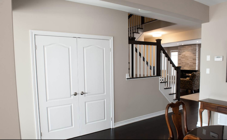Photo of a mid-sized transitional wood l-shaped staircase in Toronto with painted wood risers.