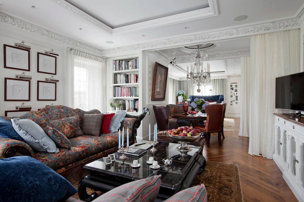 This is an example of a transitional formal living room in Moscow with white walls, medium hardwood floors, a freestanding tv and brown floor.