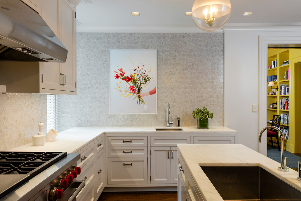 Design ideas for a mid-sized transitional l-shaped separate kitchen in New York with an undermount sink, recessed-panel cabinets, white cabinets, white splashback, mosaic tile splashback, stainless steel appliances, with island, marble benchtops and brown floor.