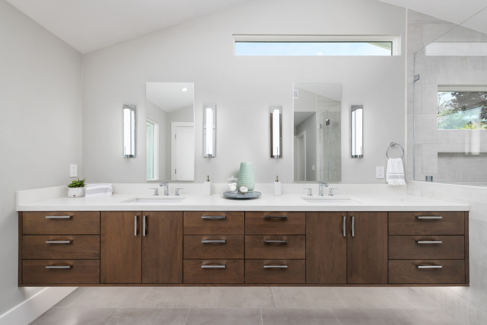 This is an example of an expansive modern master bathroom in San Francisco with flat-panel cabinets, brown cabinets, an alcove shower, a one-piece toilet, gray tile, ceramic tile, grey walls, ceramic floors, an undermount sink, engineered quartz benchtops, grey floor, a hinged shower door and white benchtops.