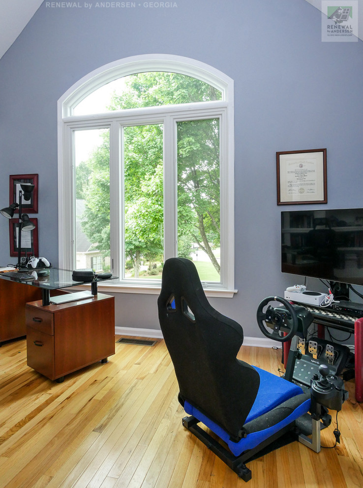 Réalisation d'un bureau de taille moyenne avec un mur bleu, un sol en bois brun, aucune cheminée, un bureau indépendant et un plafond voûté.