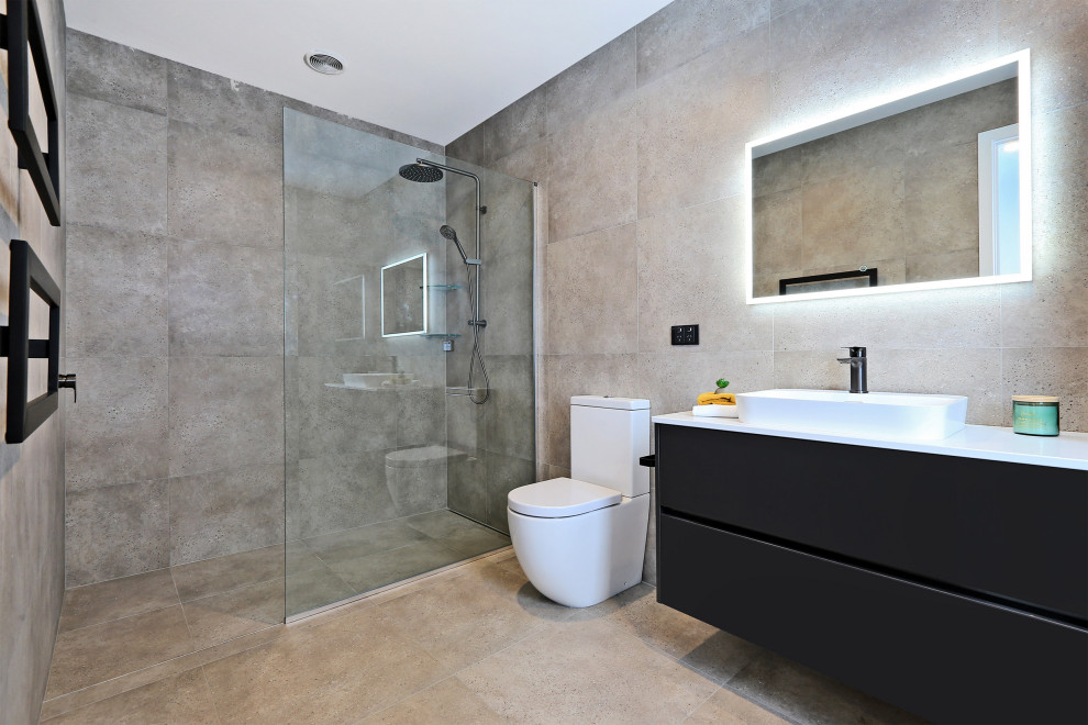 Mid-sized modern master bathroom in Napier-Hastings with flat-panel cabinets, black cabinets, an open shower, a one-piece toilet, gray tile, cement tile, white walls, cement tiles, a vessel sink, solid surface benchtops, grey floor, an open shower, white benchtops, a single vanity, a floating vanity, recessed and decorative wall panelling.