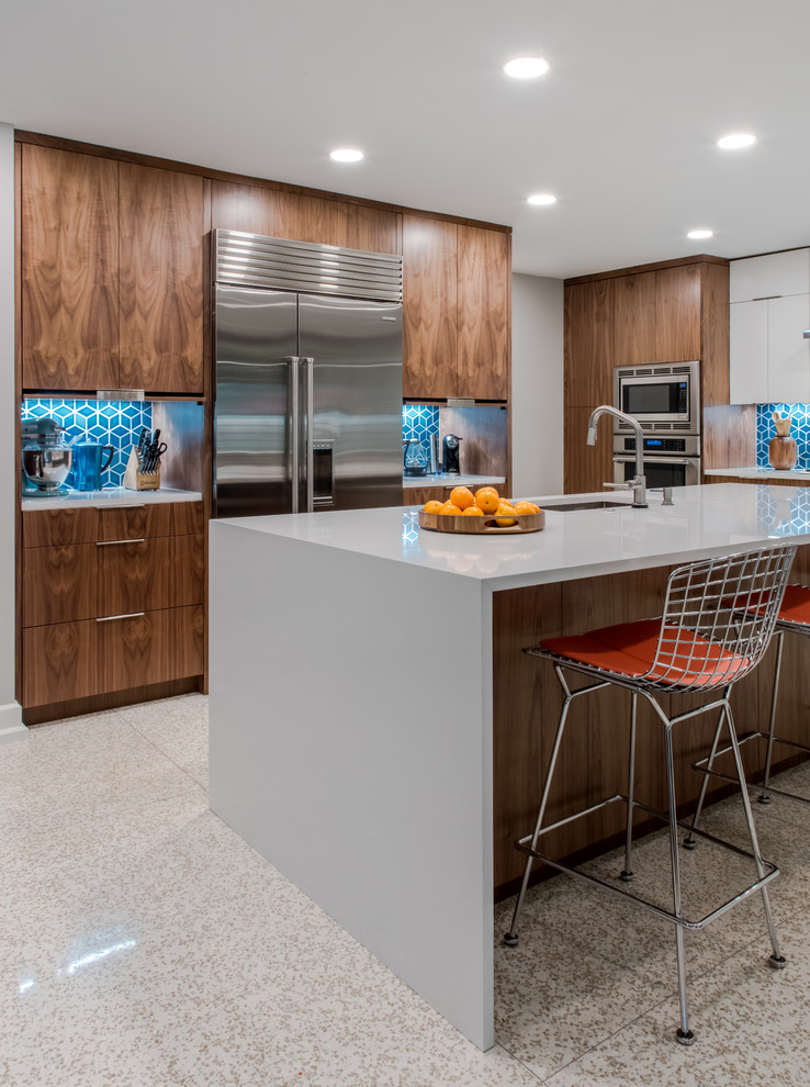 Inspiration for a mid-sized midcentury l-shaped eat-in kitchen in Austin with medium wood cabinets, blue splashback, ceramic splashback, stainless steel appliances, with island, beige floor and grey benchtop.