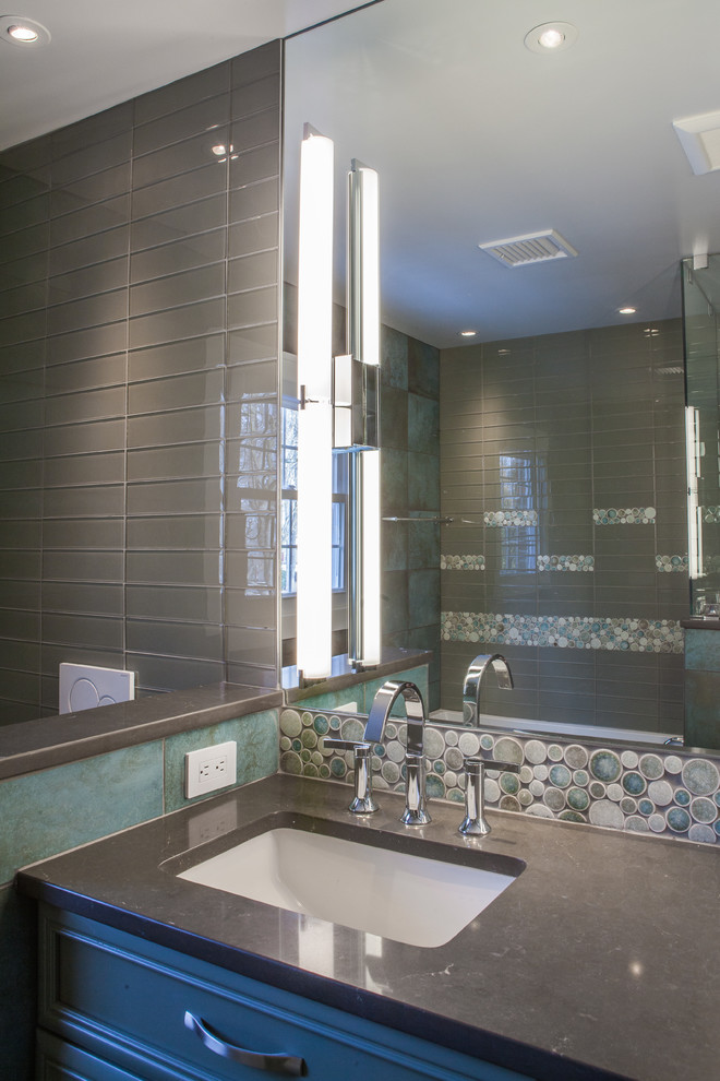 Design ideas for a mid-sized transitional bathroom in Other with raised-panel cabinets, blue cabinets, a wall-mount toilet, brown tile, glass tile, porcelain floors, an undermount sink, engineered quartz benchtops and brown benchtops.