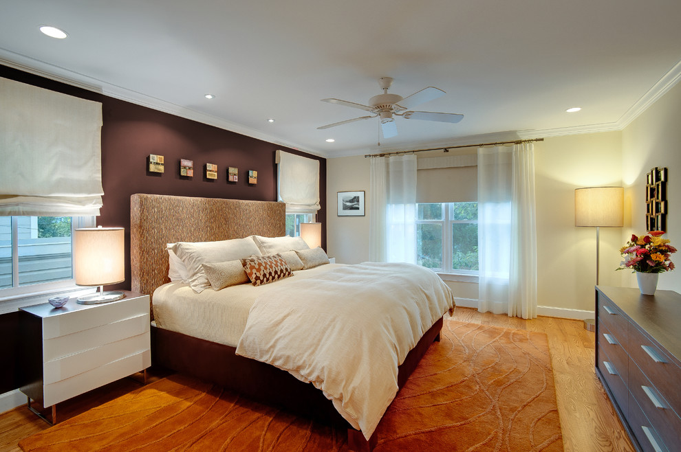 Large modern master bedroom in DC Metro with medium hardwood floors, no fireplace and brown walls.