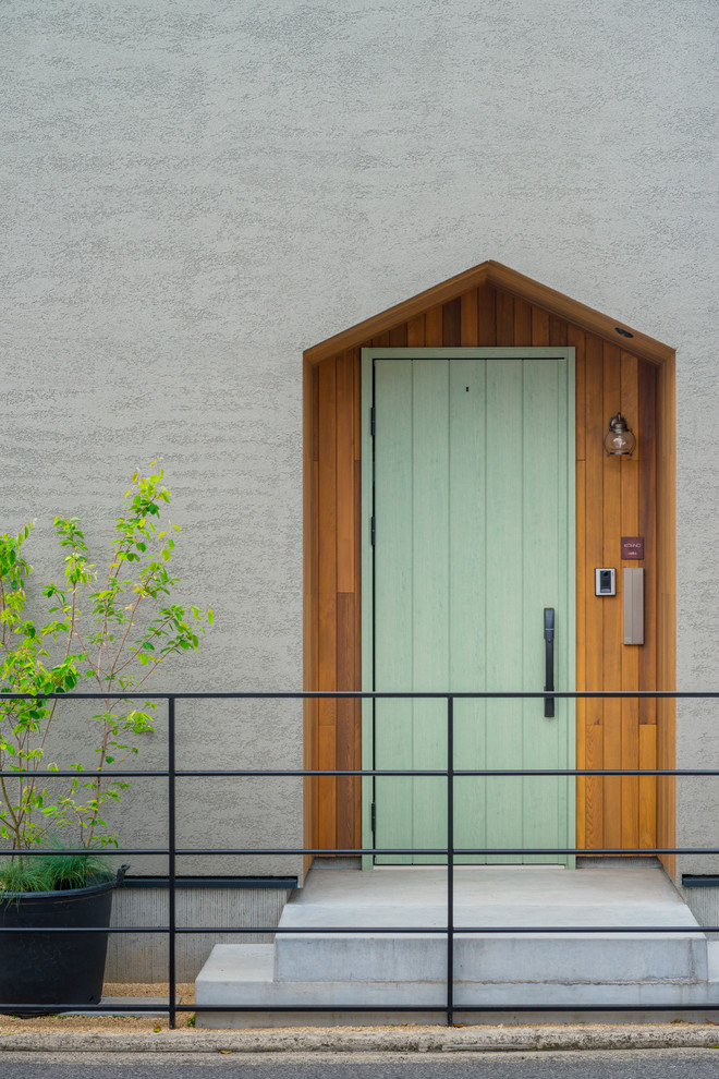 Scandinavian front door in Other with grey walls, concrete floors, a single front door, a green front door and grey floor.