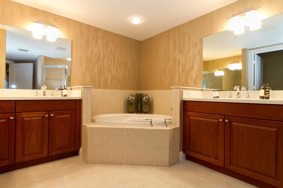 Large contemporary bathroom in Miami with an undermount sink, raised-panel cabinets, medium wood cabinets, engineered quartz benchtops, a corner tub, an alcove shower, a two-piece toilet, beige tile, porcelain tile, brown walls and porcelain floors.