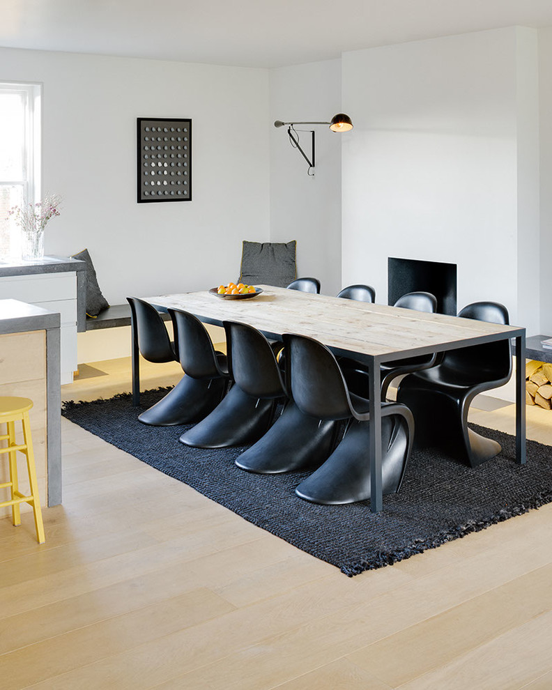 This is an example of a scandinavian open plan dining in London with white walls and light hardwood floors.