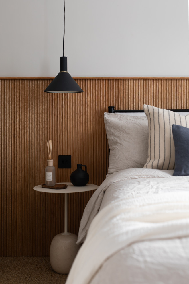 Imagen de dormitorio principal escandinavo de tamaño medio con paredes beige, moqueta, suelo beige y panelado