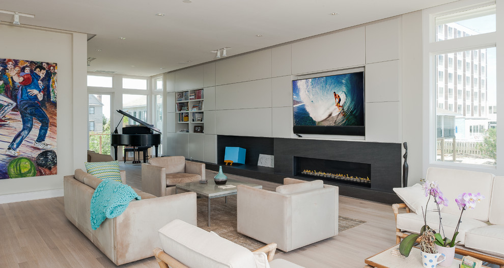 This is an example of a large beach style open concept living room in Wilmington with grey walls, light hardwood floors, a ribbon fireplace, a stone fireplace surround and a built-in media wall.