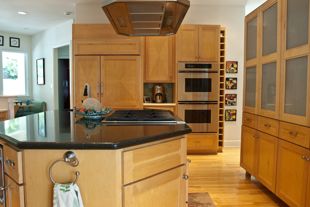 Transitional l-shaped light wood floor eat-in kitchen photo in Dallas with recessed-panel cabinets, light wood cabinets, granite countertops, multicolored backsplash, ceramic backsplash, stainless steel appliances and an island