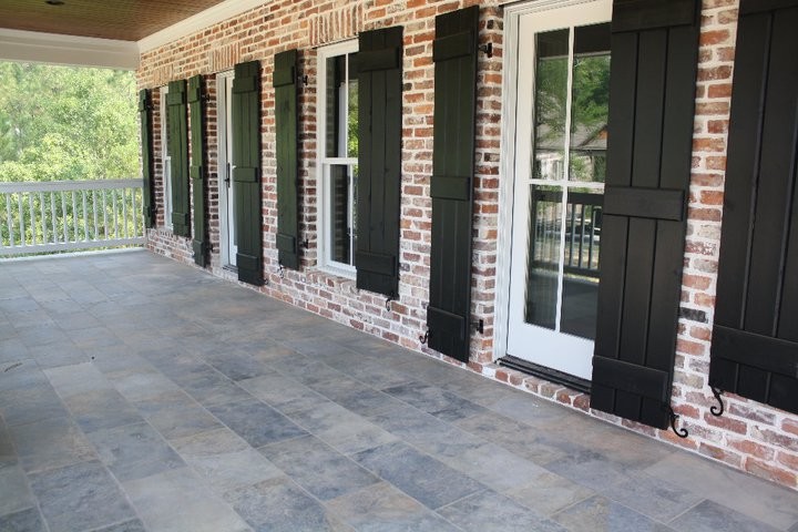 Inspiration for a mid-sized traditional front yard verandah in Atlanta with natural stone pavers and a roof extension.