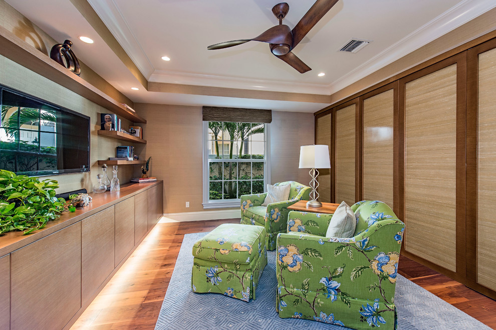 This is an example of a tropical home office in Miami with dark hardwood floors.