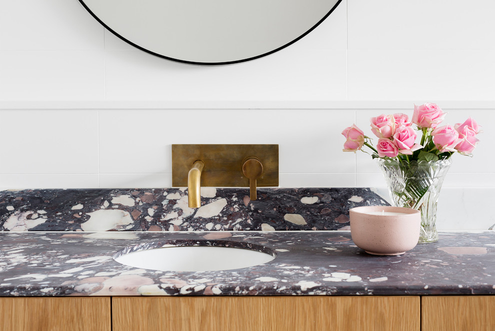 Design ideas for a large contemporary master bathroom in Melbourne with flat-panel cabinets, light wood cabinets, a freestanding tub, an alcove shower, a one-piece toilet, cement tile, cement tiles, an integrated sink, marble benchtops and black floor.