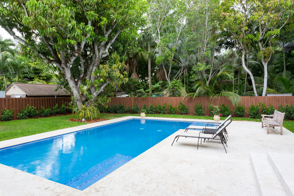 Inspiration for a mid-sized beach style backyard l-shaped natural pool in Miami with natural stone pavers.