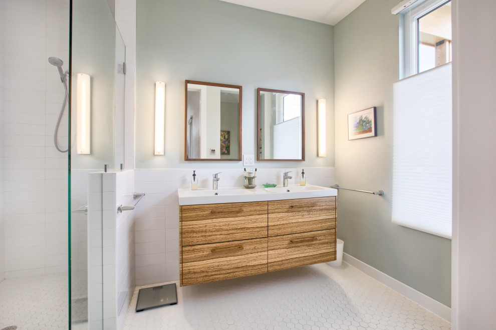 Ispirazione per una stanza da bagno padronale moderna di medie dimensioni con ante lisce, ante in legno chiaro, piastrelle bianche, top bianco, due lavabi e mobile bagno sospeso