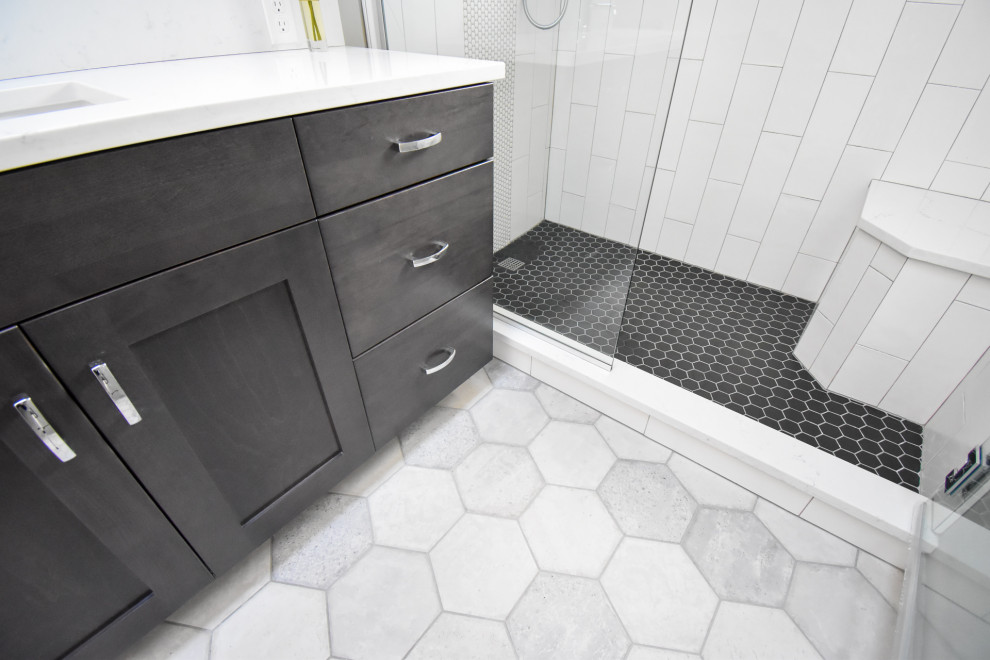 This is an example of a mid-sized modern master bathroom in Portland with shaker cabinets, black cabinets, an alcove shower, a two-piece toilet, white tile, porcelain tile, grey walls, porcelain floors, an undermount sink, engineered quartz benchtops, grey floor, a hinged shower door, white benchtops, a shower seat, a single vanity and a built-in vanity.
