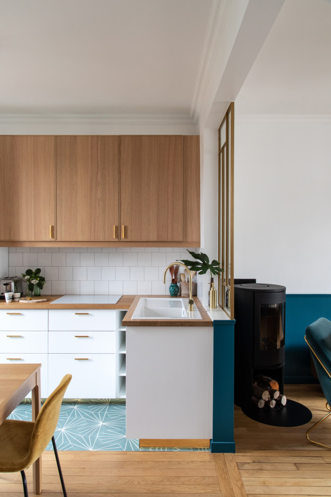 Design ideas for a mid-sized modern l-shaped open plan kitchen in Paris with a single-bowl sink, beaded inset cabinets, light wood cabinets, wood benchtops, white splashback, ceramic splashback, white appliances, cement tiles, no island, blue floor and beige benchtop.