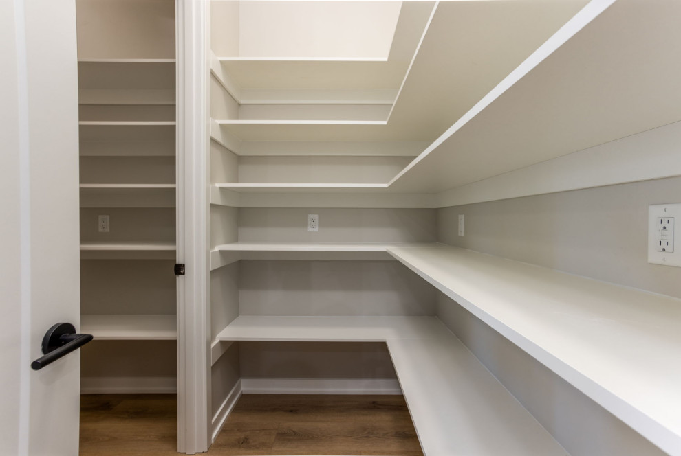 Kitchen pantry - rustic l-shaped kitchen pantry idea with dark wood cabinets, beige backsplash, stainless steel appliances, an island and white countertops