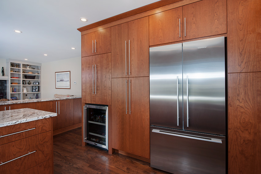 Inspiration for a mid-sized transitional u-shaped dark wood floor open concept kitchen remodel in Calgary with an undermount sink, flat-panel cabinets, medium tone wood cabinets, granite countertops, white backsplash, mirror backsplash, stainless steel appliances and an island