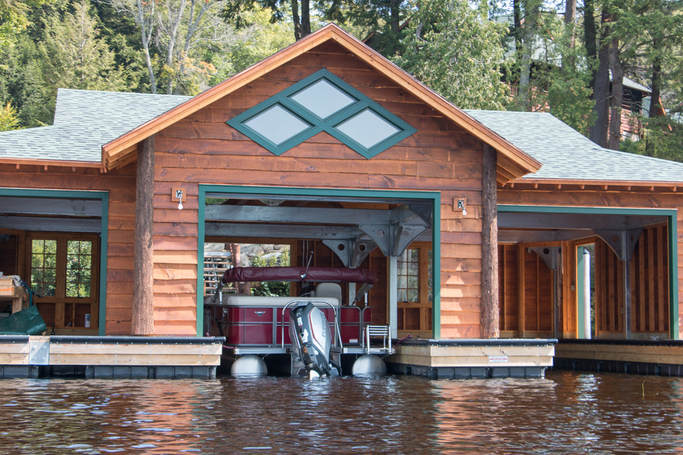 Пример оригинального дизайна: отдельно стоящий лодочный гараж в стиле рустика для двух машин