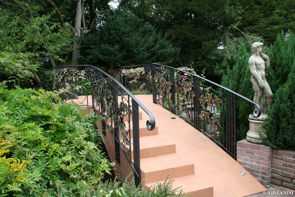 Ispirazione per un giardino formale tradizionale esposto in pieno sole di medie dimensioni e davanti casa in primavera con un ingresso o sentiero, pedane e recinzione in metallo