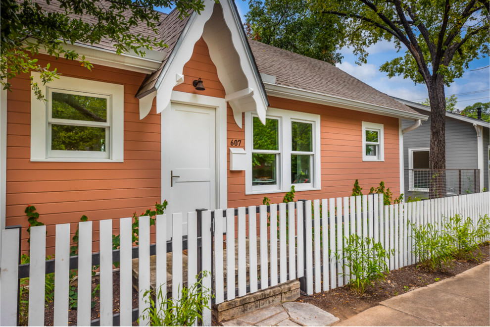 Design ideas for a small transitional one-storey orange house exterior in Austin with wood siding, a gable roof, a shingle roof, a brown roof and clapboard siding.
