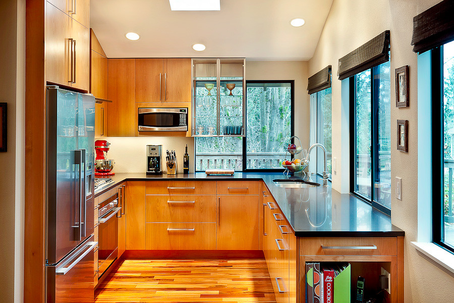 Inspiration for a modern u-shaped separate kitchen in Seattle with an undermount sink, flat-panel cabinets, medium wood cabinets, granite benchtops and stainless steel appliances.