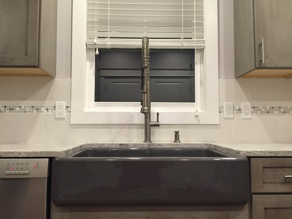 Inspiration for a large transitional l-shaped medium tone wood floor eat-in kitchen remodel in Grand Rapids with a farmhouse sink, shaker cabinets, gray cabinets, quartz countertops, white backsplash, porcelain backsplash, stainless steel appliances and an island