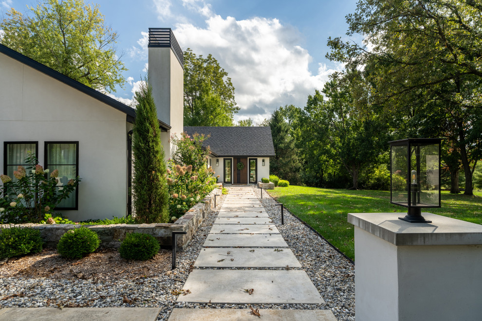 Example of a large minimalist white one-story stucco house exterior design in Other with a hip roof, a shingle roof and a gray roof