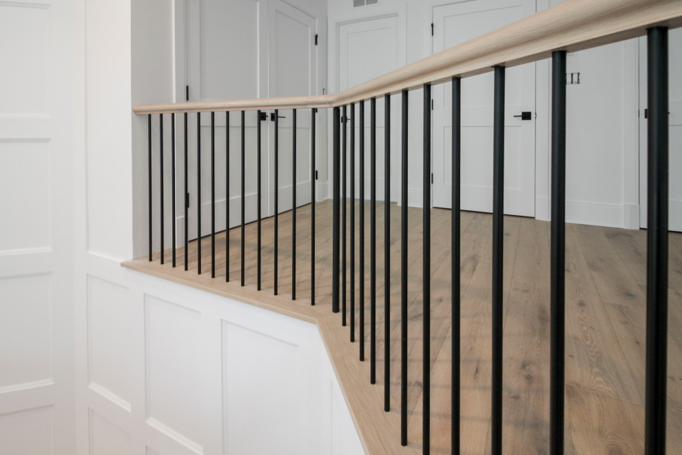 Design ideas for a large classic wood floating mixed railing staircase in DC Metro with painted wood risers and wainscoting.