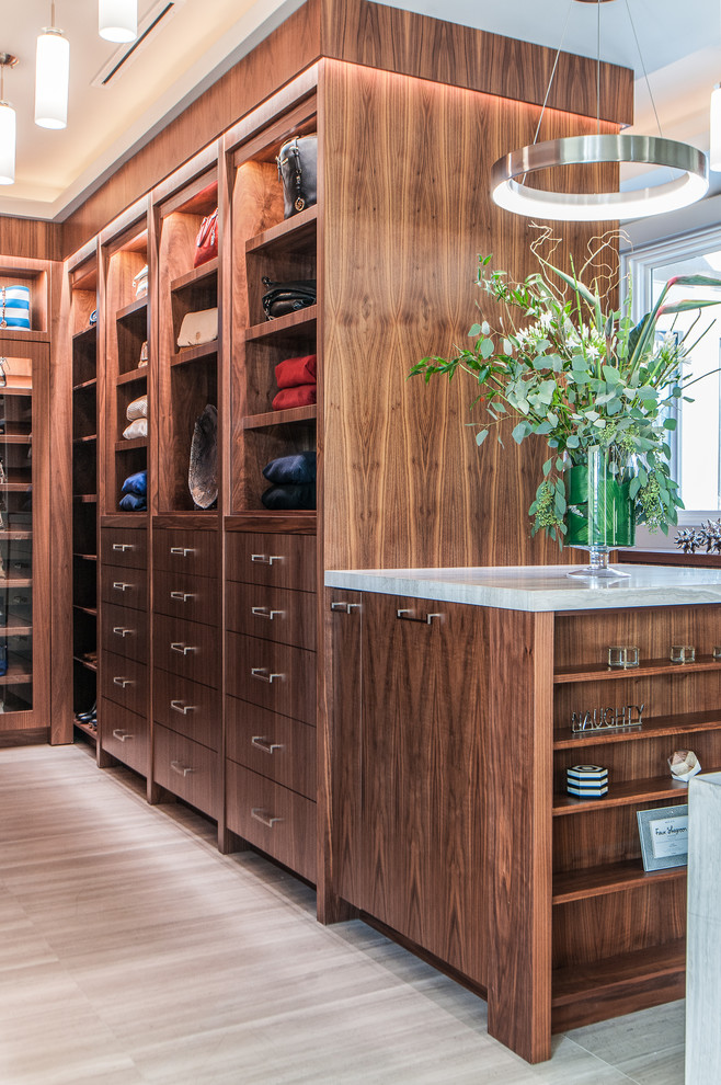 Inspiration for a large contemporary gender-neutral walk-in wardrobe in Toronto with flat-panel cabinets, medium wood cabinets, ceramic floors and beige floor.