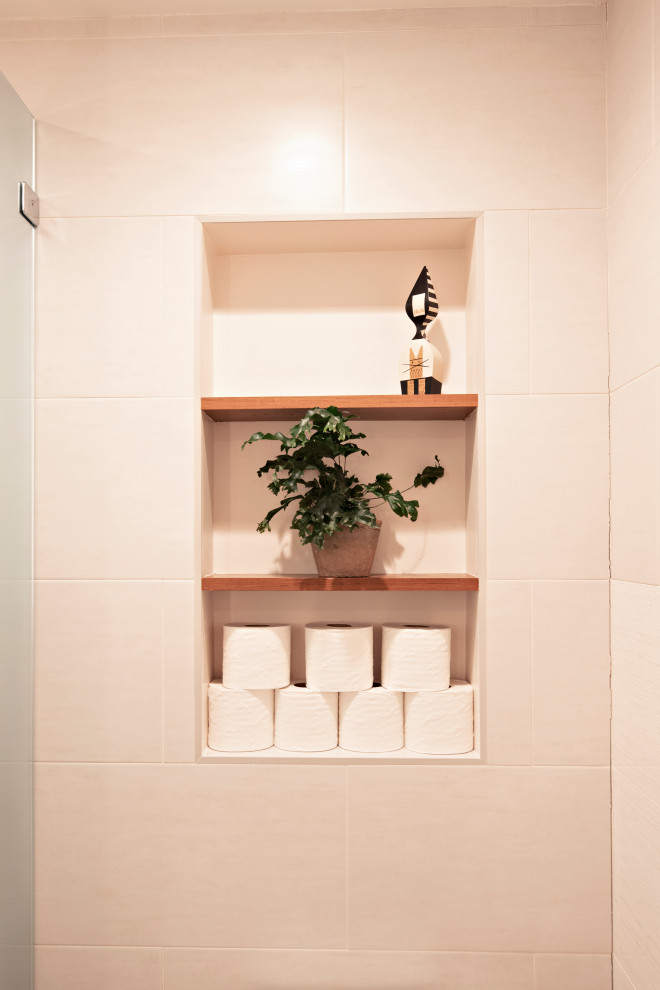 Источник вдохновения для домашнего уюта: главная ванная комната среднего размера в стиле модернизм с плоскими фасадами, фасадами цвета дерева среднего тона, ванной в нише, открытым душем, унитазом-моноблоком, бежевыми стенами, полом из керамогранита, раковиной с несколькими смесителями, столешницей из искусственного кварца, бежевым полом, открытым душем, нишей, тумбой под одну раковину и подвесной тумбой
