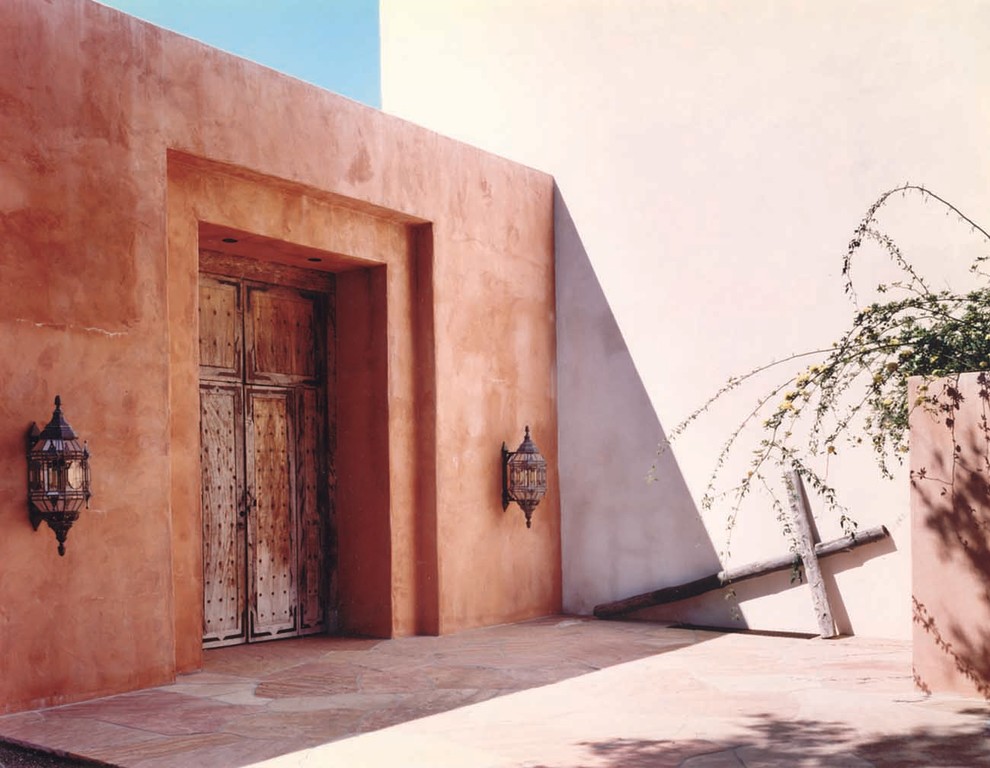 Inspiration for a large two-storey adobe red exterior in Santa Barbara with a flat roof.