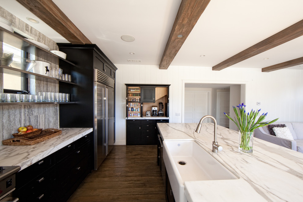 Inspiration for a contemporary galley open plan kitchen in Orange County with a farmhouse sink, open cabinets, stone slab splashback, black cabinets, marble benchtops, grey splashback, dark hardwood floors, with island and brown floor.