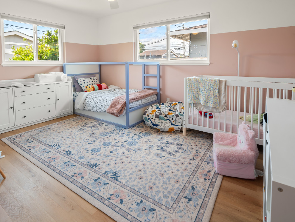 Modelo de habitación de bebé neutra abovedada nórdica de tamaño medio con paredes rosas, suelo vinílico y suelo beige