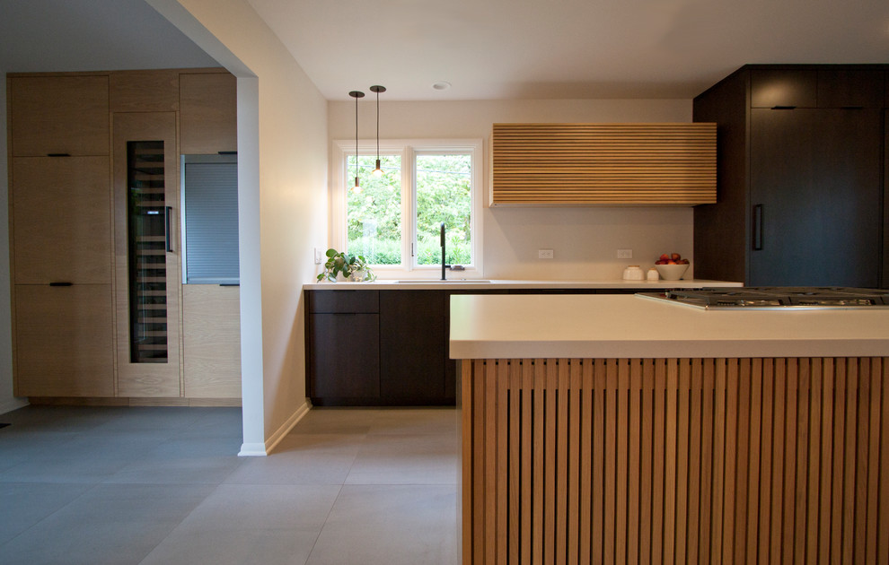 Foto di una cucina moderna di medie dimensioni con lavello sottopiano, ante lisce, ante in legno bruno, top in quarzo composito, paraspruzzi bianco, elettrodomestici neri, pavimento in gres porcellanato e pavimento grigio