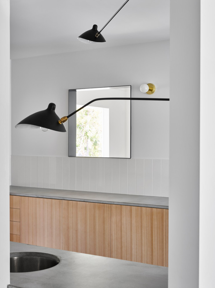 Design ideas for a small contemporary galley eat-in kitchen in Brisbane with a double-bowl sink, light wood cabinets, concrete benchtops, white splashback, ceramic splashback, stainless steel appliances, dark hardwood floors and black floor.