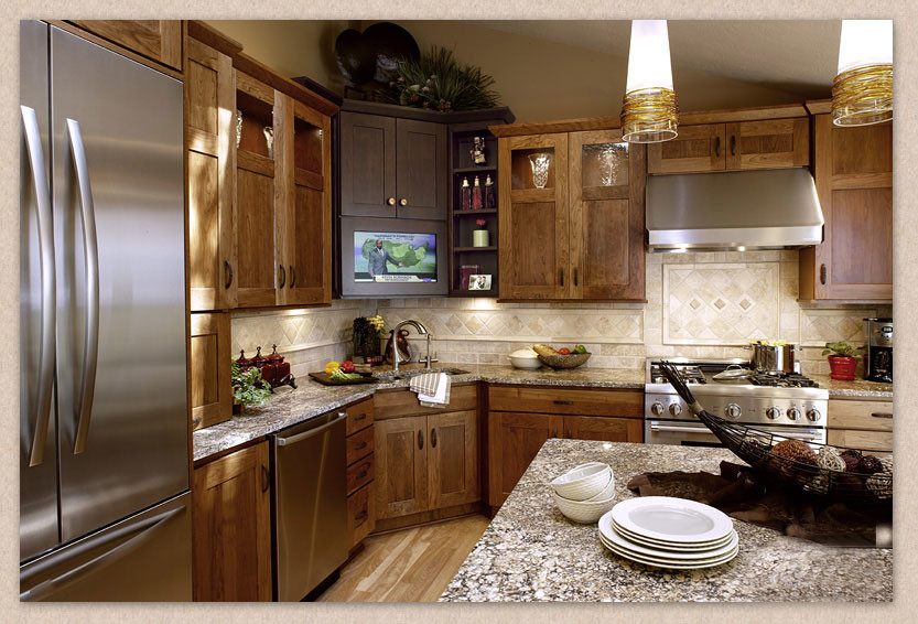 Mid-sized transitional l-shaped light wood floor enclosed kitchen photo in Cincinnati with an undermount sink, shaker cabinets, medium tone wood cabinets, granite countertops, beige backsplash, stone tile backsplash, stainless steel appliances and an island