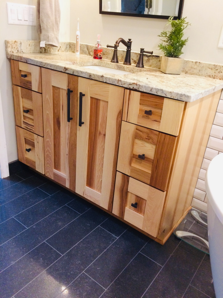 Mountain style white tile and subway tile ceramic tile, blue floor and single-sink bathroom photo with shaker cabinets, medium tone wood cabinets, granite countertops and beige countertops