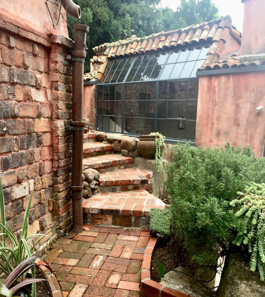 Photo of a large traditional courtyard partial sun formal garden for spring in San Francisco with with rock feature and brick pavers.